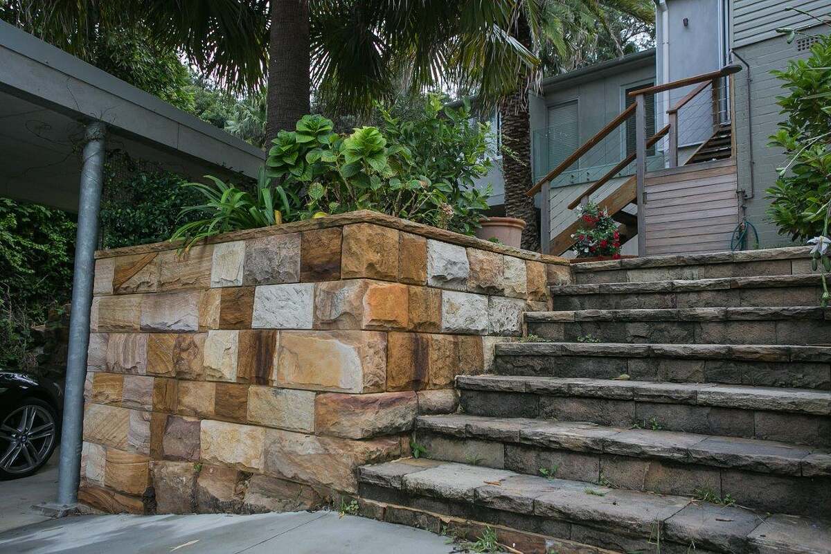 Sandstone block garden wall beside sandstone steps leading up to a Bilgola Beach home