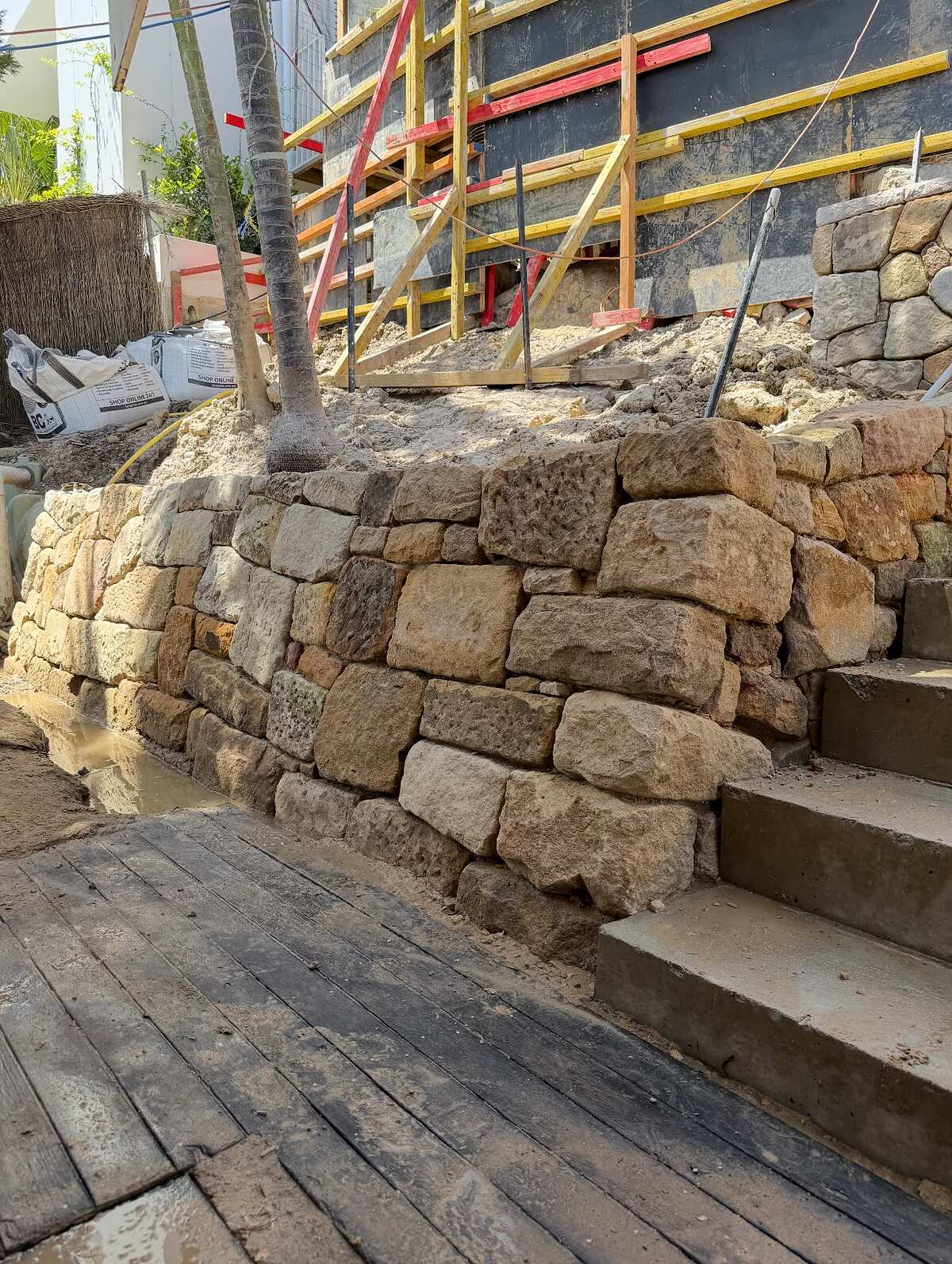 Drystone sandstone retaining wall with sawn sandstone block steps on a sloping site