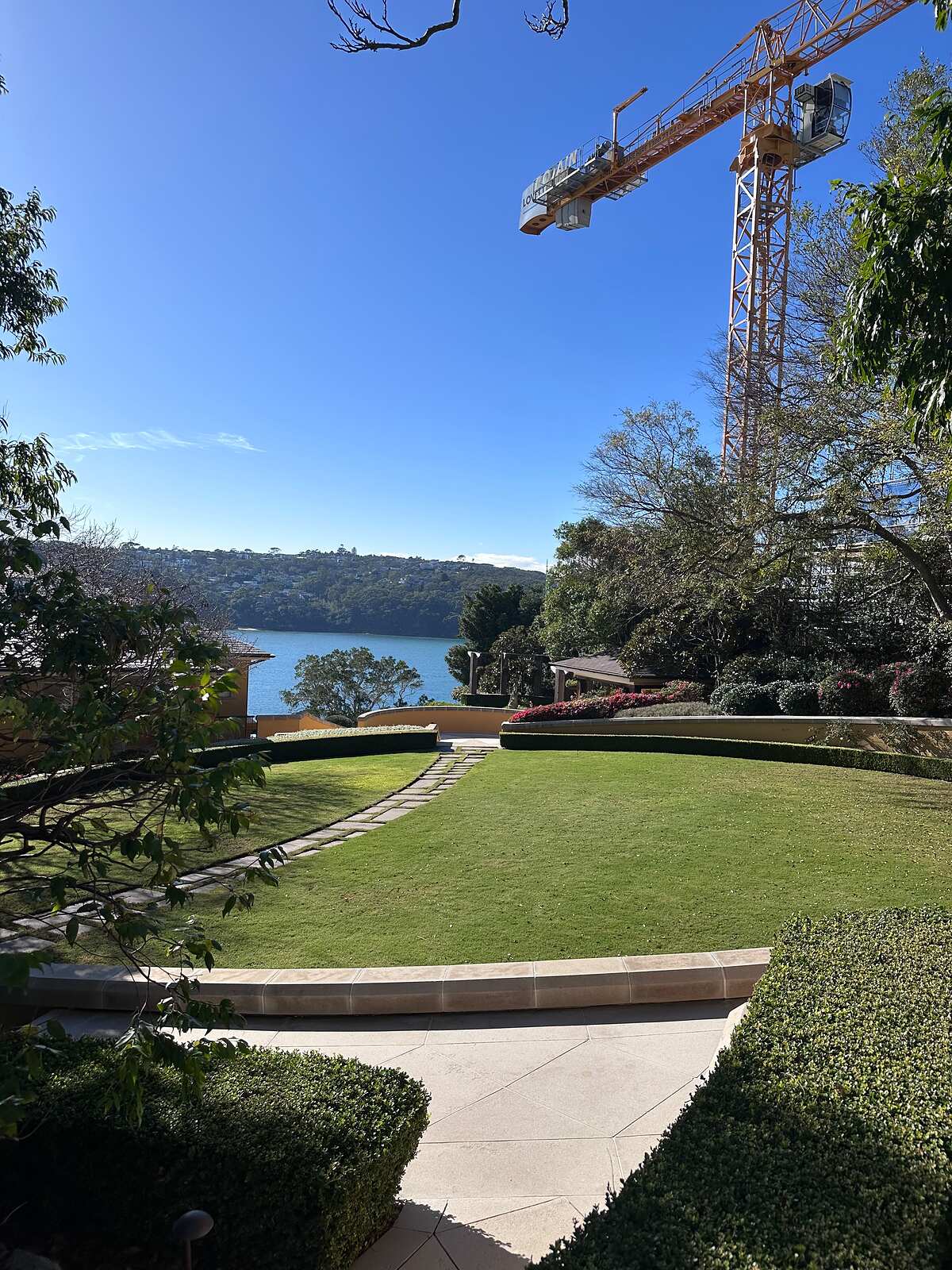 Harbourside garden lawn with curved sandstone-capped walls and stepping-stone path
