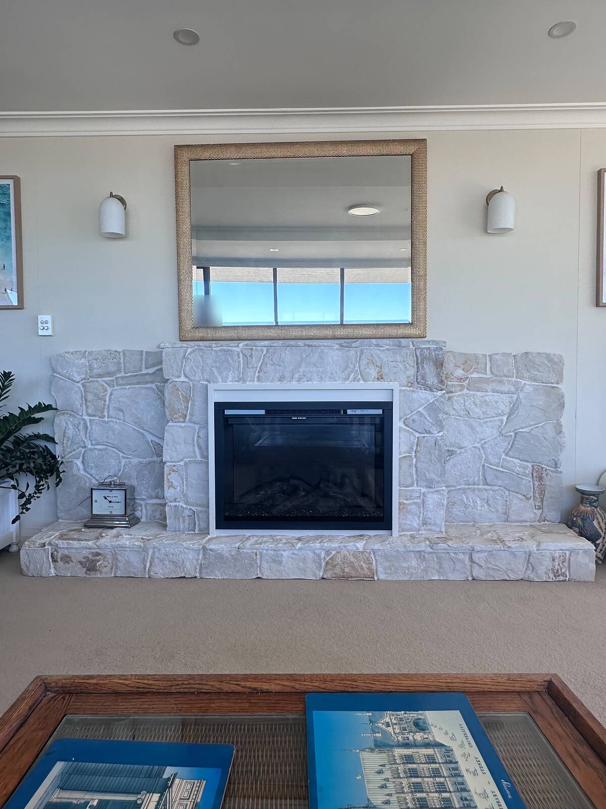 Light random natural stone fireplace with raised block hearth in a coastal living room