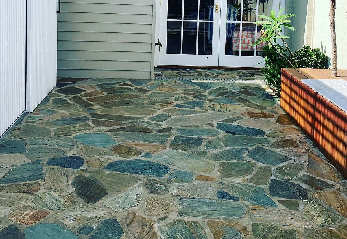 Close view of multi-coloured quartzite crazy paving in a courtyard outside French doors