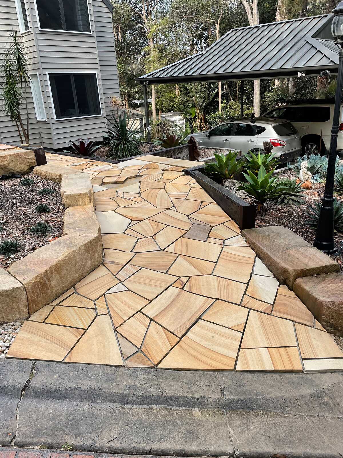 Sandstone crazy paving entry path edged with large sandstone blocks outside a weatherboard home