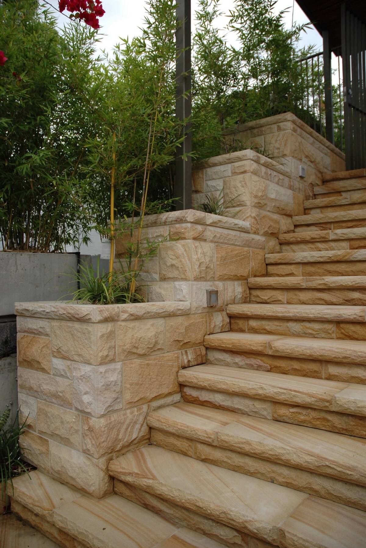 Sawn sandstone garden stairs between sandstone block walls and bamboo planting