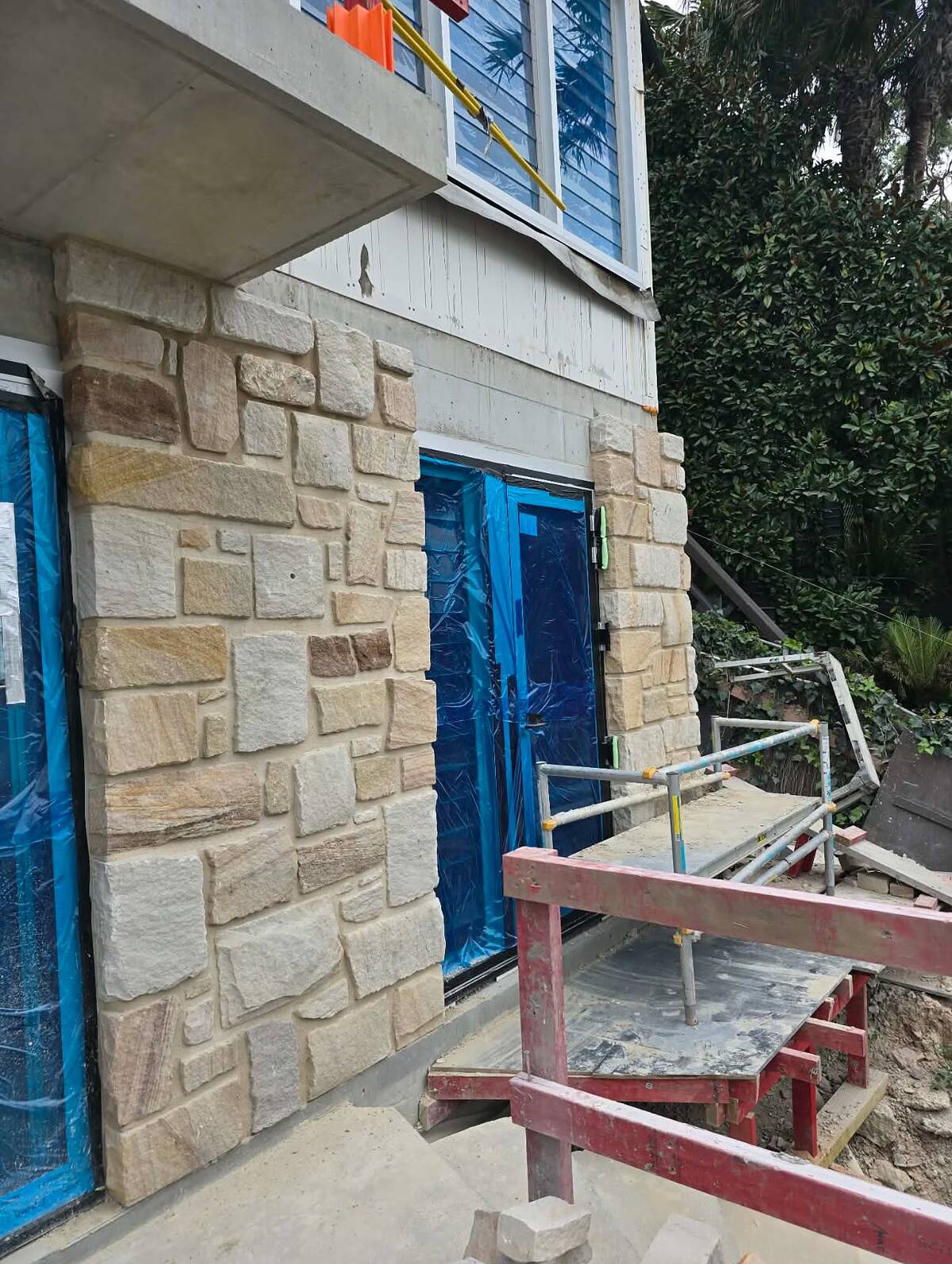 Split-face sandstone cladding around a ground-floor doorway on a renovated house